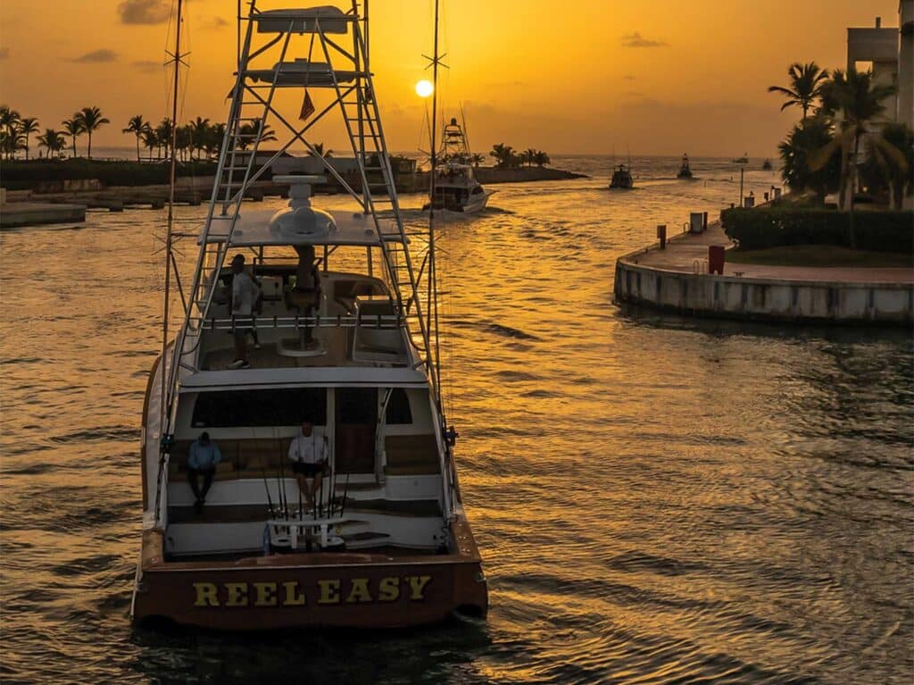 A sport-fishing boat cruises out of the marina.