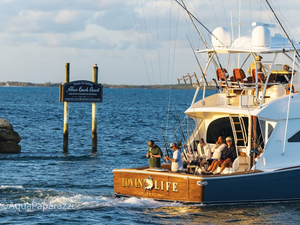 A sport-fishing boat cruising past the Abaco Beach resort sign.