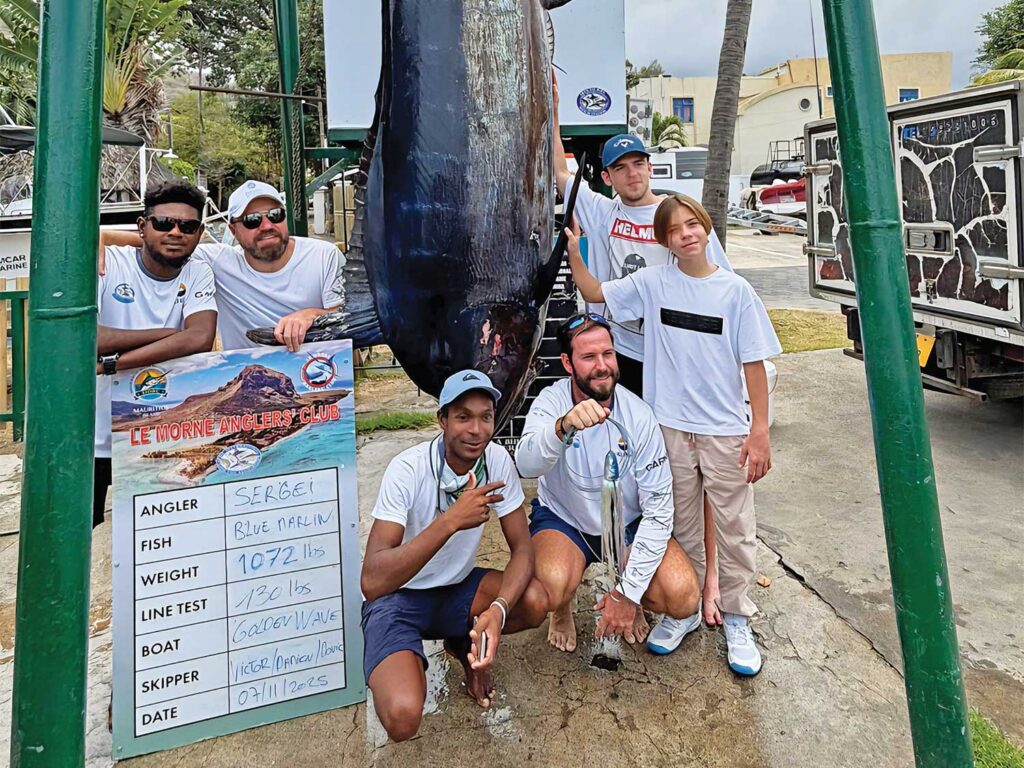 A team of anglers next to a large grander marlin.