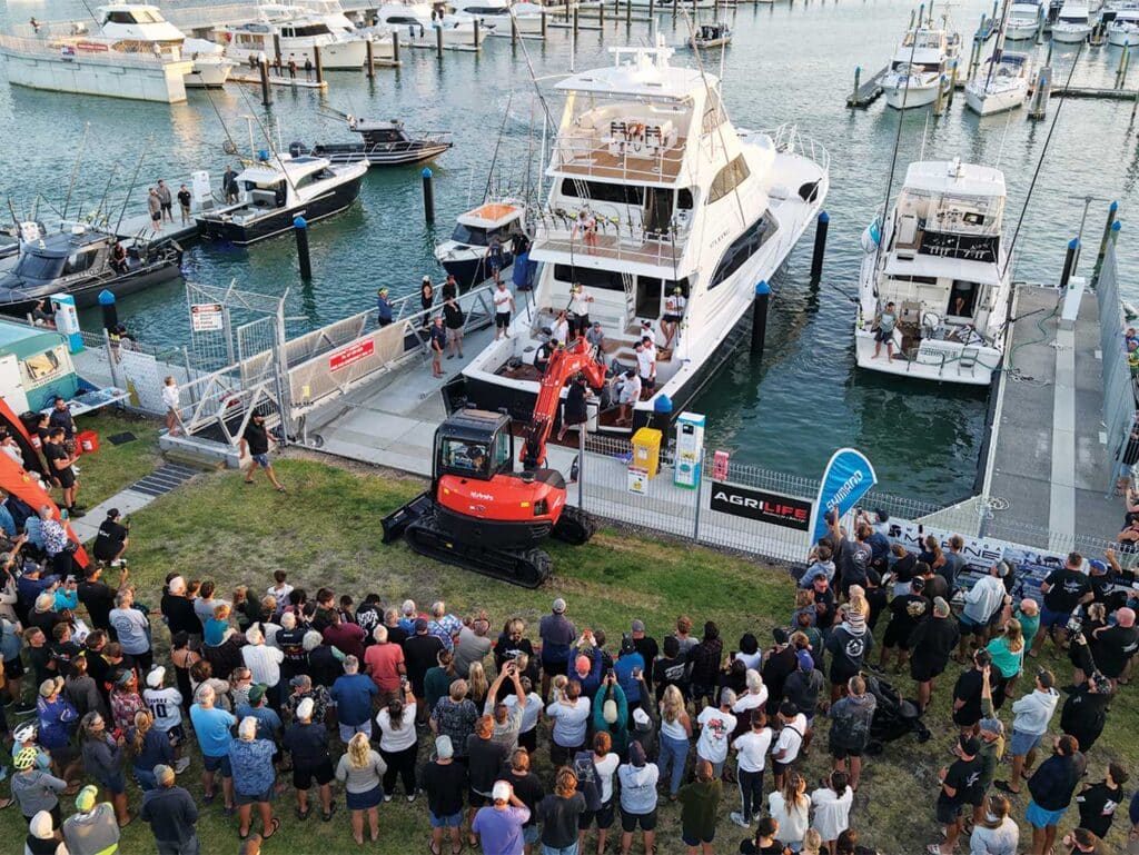 A view of a crowd nearing a marlin weighing.