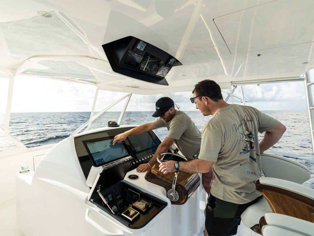 Two men at the helm of a sport-fishing boat.