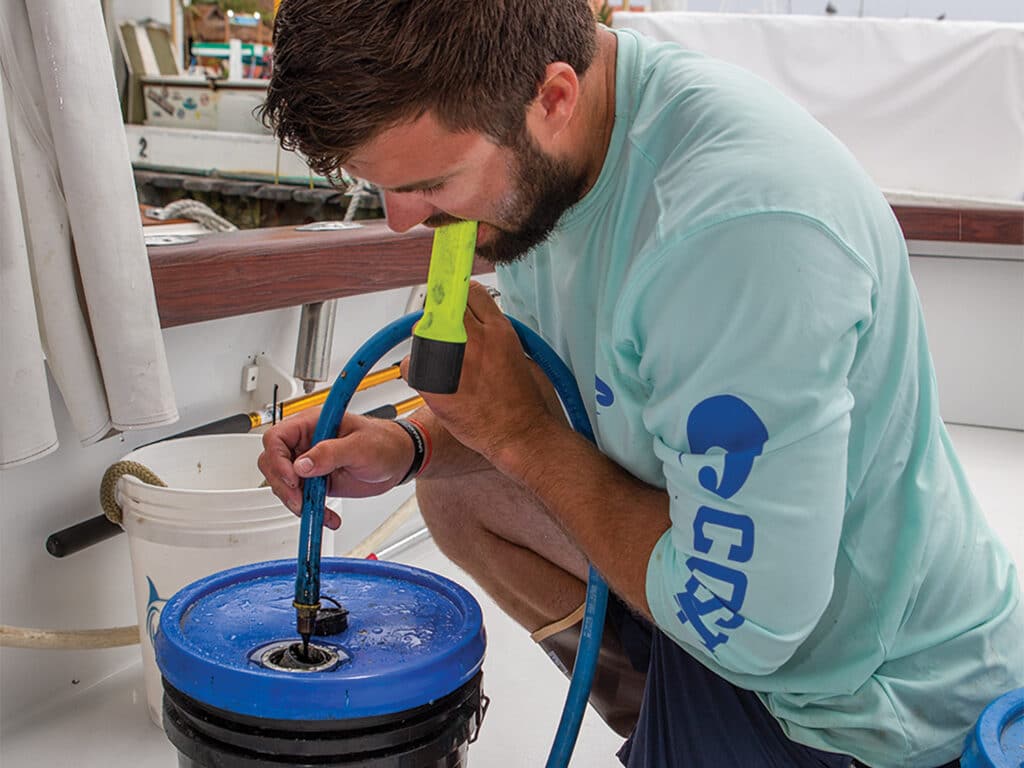 Crew filling a container with oil.