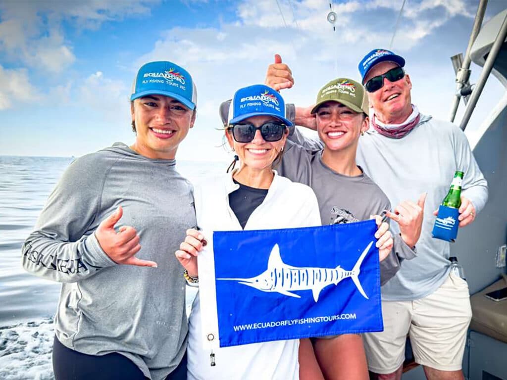 fishing expeditions team holding a release flag