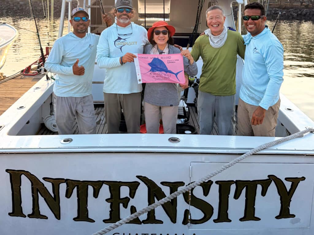 Anglers hold up a pink sailfish release flag.