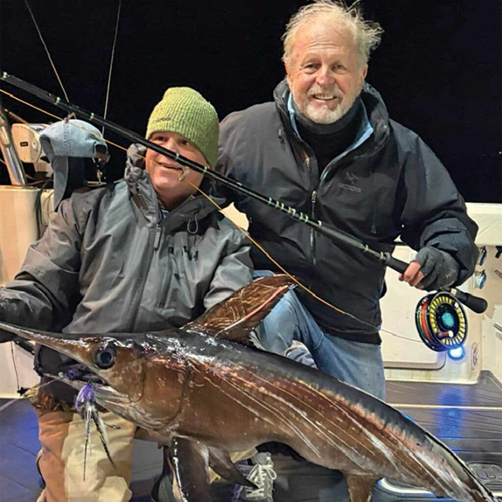 Two anglers holding a marlin
