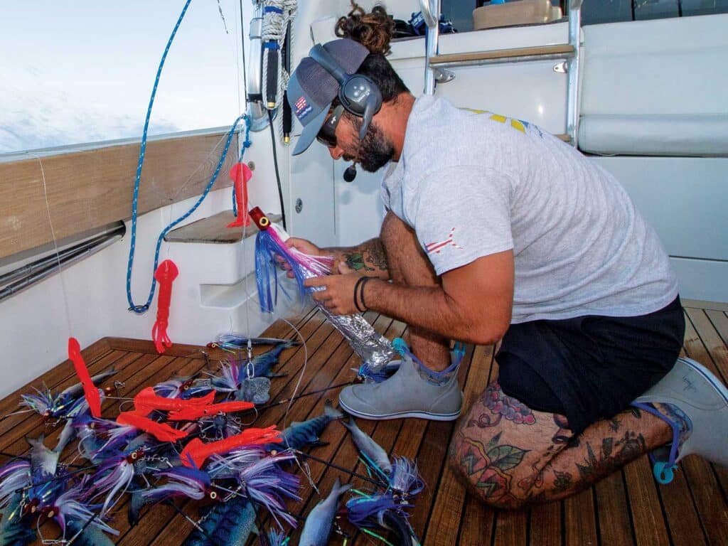 Angler preparing bait in the cockpit of a sport-fishing boat.