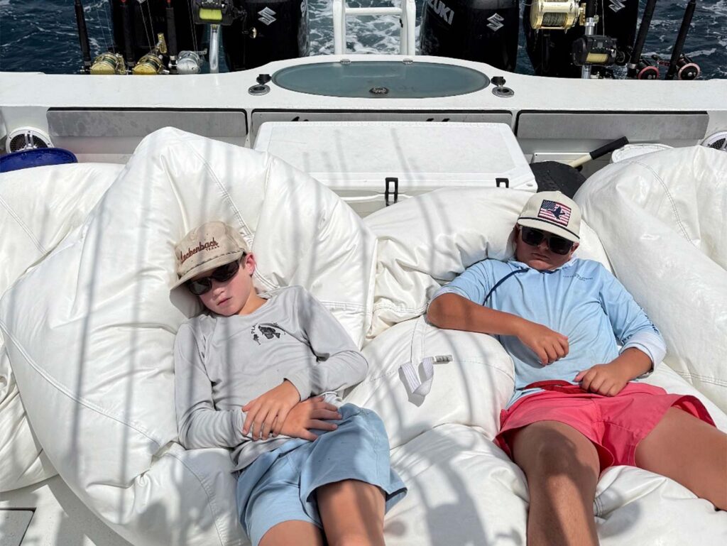 two kids asleep on a boat